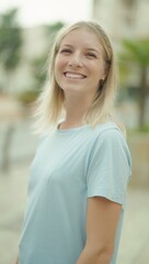 Young blonde woman smiling confident standing at street