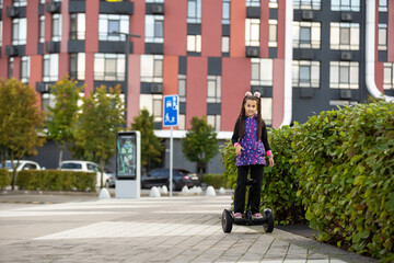 A little girl riding a electric scooter. Personal eco transport, gyro scooter, smart balance wheel. Popular electric transport