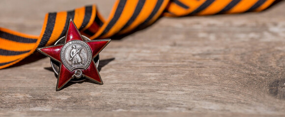 St. George's ribbon and the Order of the Red Star of the USSR World War II veteran on a wooden...