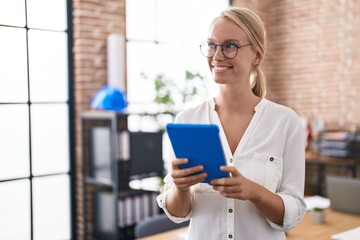 Young blonde woman business worker using touchpad at office