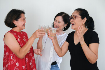 Three women on casual clothing having some drinks in a cocktail party