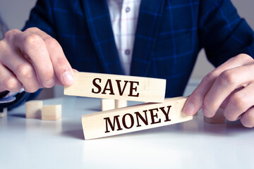 Obraz premium Closeup on businessman holding a wooden block with Save Money message, business concept