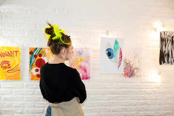 young woman artist, teenage girl with green hair, art school student studying paintings at an exhibition in a gallery