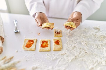 Young woman wearing cook uniform cooking pasta at kitchen