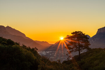 Obraz premium Landscape, the sun rises between the mountains, forming beautiful rays of light, landscape of trees and mountains, clear sky