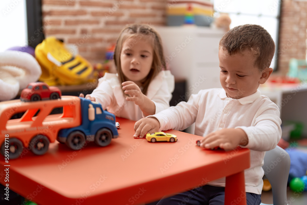 Poster adorable girl and boy playing with toys on table at kindergarten