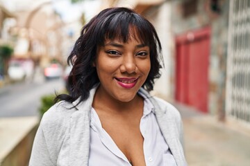 Fototapeta premium Young beautiful latin woman smiling confident standing at street