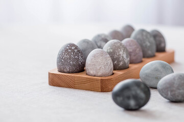 Fototapeta na wymiar Stylish grey Easter eggs in marble and concrete on a wooden stand. Coloring eggs with natural dye karkade tea. Environmental friendliness. Naturalness. The concept of happy Easter 2023.