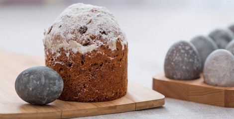 Stylish grey Easter eggs in marble and concrete and a cake on a wooden stand. Coloring eggs with natural dye karkade tea. Environmental friendliness. Naturalness. The concept of happy Easter 2023.