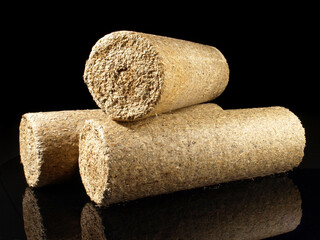 Round Needlewood Sawdust Briquettes - Compressed Biomass Wood Fire Logs isolated on black Background
