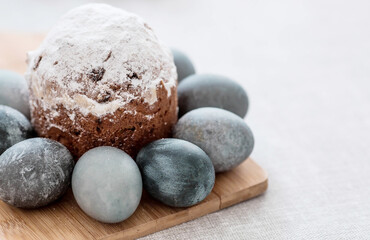 Fototapeta na wymiar Stylish grey Easter eggs in marble and concrete and a cake on a wooden stand. Coloring eggs with natural dye karkade tea. Environmental friendliness. Naturalness. The concept of happy Easter 2023.