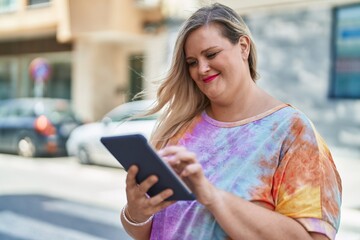 Young woman smiling confident using touchpad at street