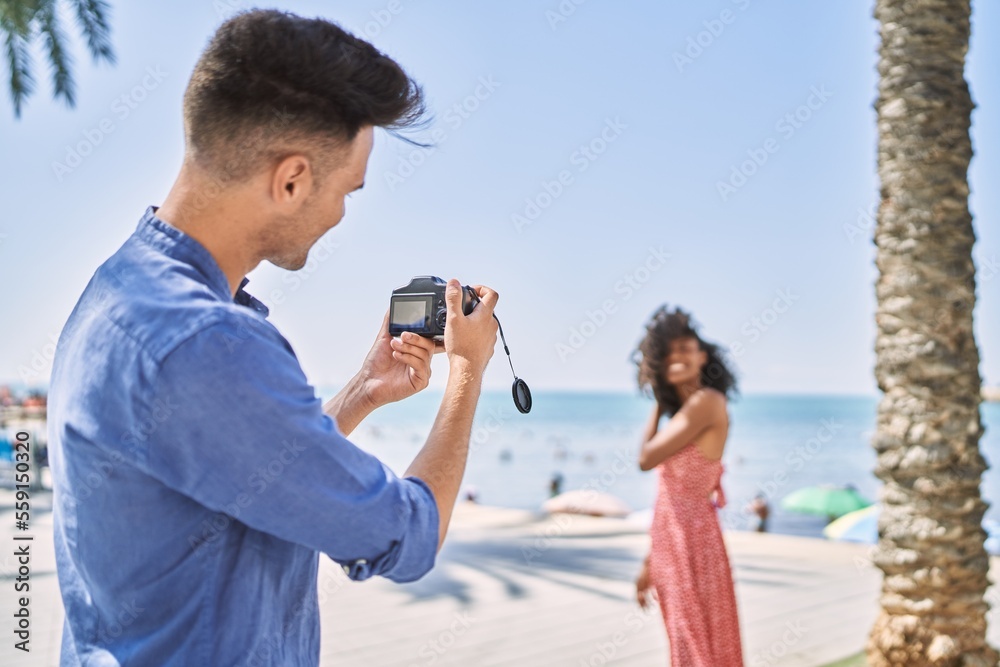 Wall mural Man and woman couple make photo using camera at seaside