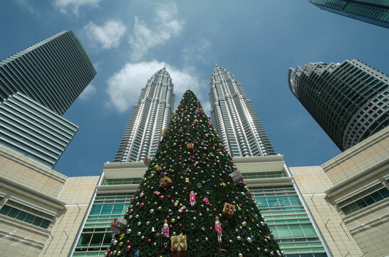 'Kuala Lumpur, Malaysia- Circa January, 2022: Low angle and noise effect picture of tall christmas tree with Kuala Lumpur Twin Tower insight.