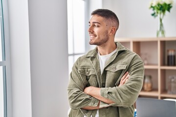 Young hispanic man smiling confident standing with arms crossed gesture at home