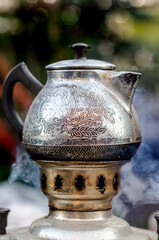 Vintage weathered charcoal burning samovar, preparing tea outside