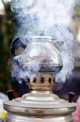 Vintage iron teapot on smoke, Incandescent coal fire in the samovar prepaire tea outside