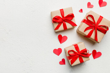 Valentine day composition: red gift box with bow and heart. Christmas present. View from above. Space for text. Holday greeting card