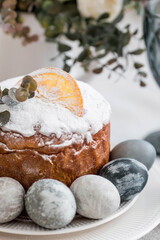 Spring table setting. A plate with a cotton napkin with a bunny, a cake and Easter eggs. Silverware, Easter bunnies and a vase of flowers on a linen tablecloth. The concept of a bright Easter holiday.