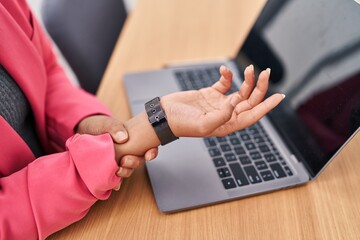Young beautiful hispanic woman business worker suffering for wrist pain working at office