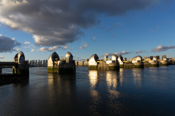 Thames Barrier in London with blue sky and dark clouds