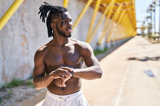African american woman shirtless using stopwatch at street