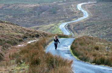 Woman running along the road among the mountains
