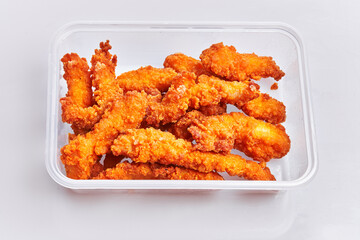  Delicious fried chicken on delivery plastic box over isolated white background