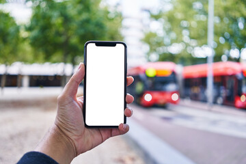 Man holding smartphone showing white blank screen at bus stop