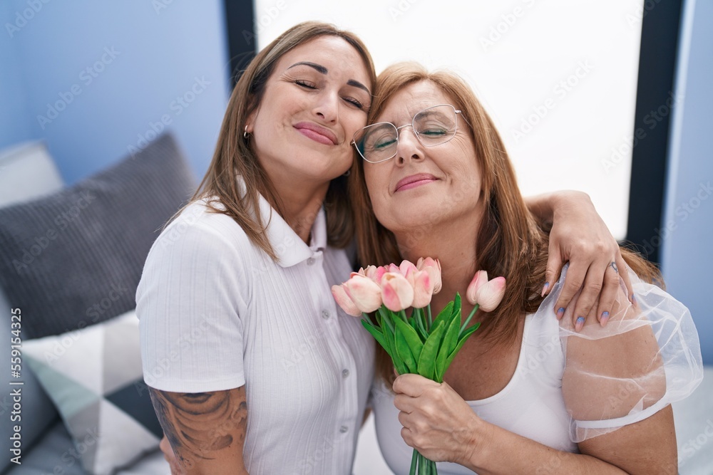 Sticker Mother and daughter surprise with flowers hugging each other at home