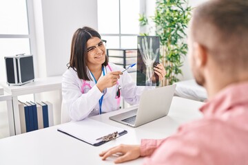 Man and woman doctor and patient having medical consultation holding xray at clinic