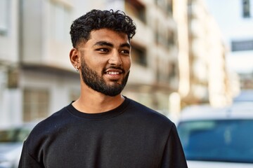 Young arab man smiling confident at street