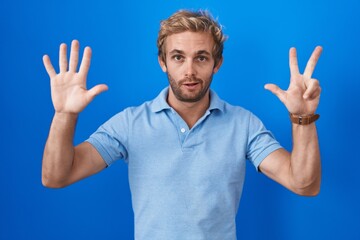 Caucasian man standing over blue background showing and pointing up with fingers number eight while smiling confident and happy.