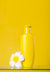 Blank mock up bottle beauty cosmetic skin care organic product for bathing routine with flower plumeria frangipani on yellow background. Place your design.