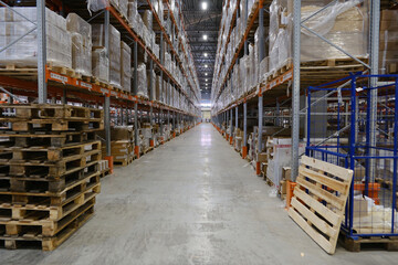 Row with racks of goods on shelves inside warehouse