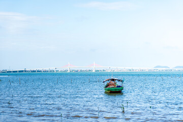 The scenery of the estuary with the bridge crossing is very beautiful, the sky is clear and the small boats are ready to go fishing