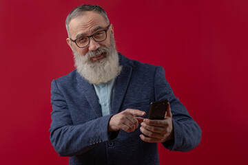 Senior charismatic man holding a smartphone