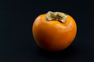Natural and Organic Kaki fruit (Turkish: persimmon) on black background