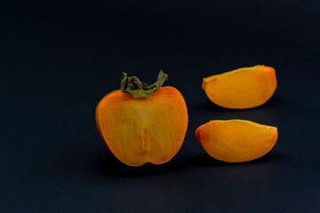 Natural and Organic Kaki fruit (Turkish: persimmon) on black background