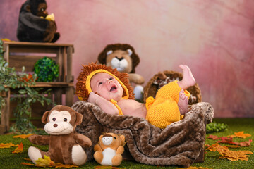Newborn baby dressed as the lion king smiling happily