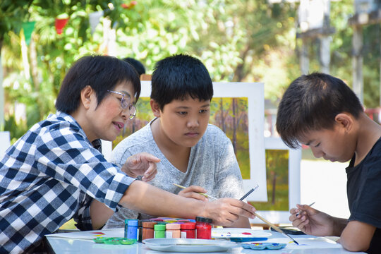 Asian Outdoor Painting Study Of Asian Young Teen Boys With Their Female Teacher, Soft Focus, Raising Teens Concept.