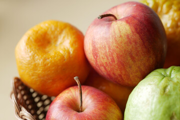 close up of apple and orange in a bowl on orange background .
