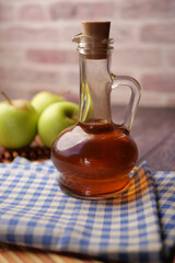 apple vinegar in glass bottle with fresh green apple on table 