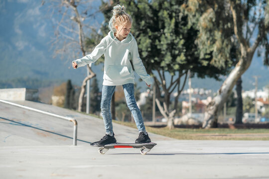 Girl riding on waveboard with two wheels, modern street skate sports of teenagers, casterboard or ripstick for balance ride.