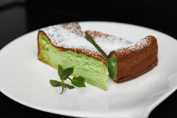 cheesecake green next to decorated with mint, on a black background