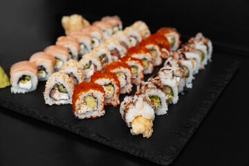 Sushi on a stone plate with black background