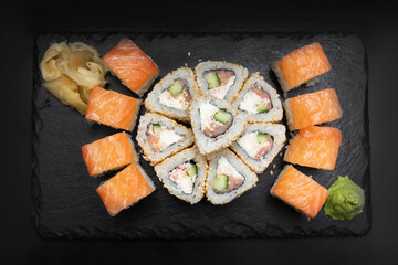 Sushi on a stone plate with black background