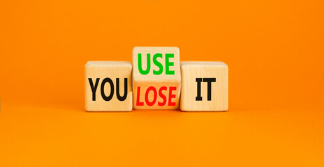 You use or lose it symbol. Concept word You use or lose it on wooden cubes. Beautiful orange table orange background. Business and TYou use or lose it concept. Copy space.