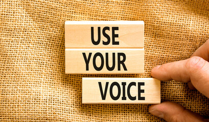 Use your voice symbol. Concept words Use your voice on wooden blocks on a beautiful canvas table canvas background. Businessman hand. Business and use your voice concept. Copy space.