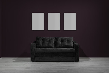 Small black soft sofa with empty pictures, loft style